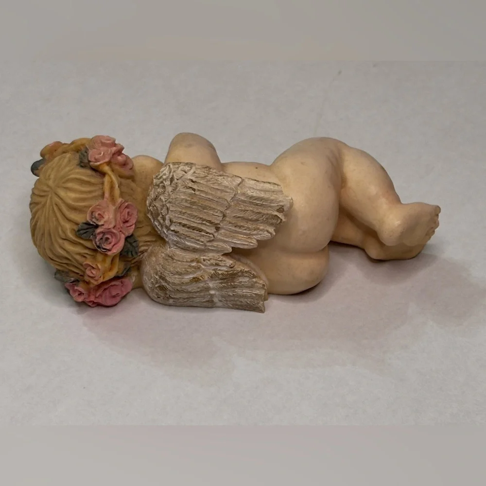 Sleeping Cherub Figurine holding a doll with Floral Crown